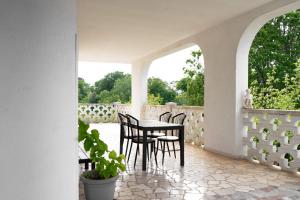 eine Veranda mit einem Tisch und Stühlen auf einer Terrasse in der Unterkunft La Dimora di Helen in Monopoli + 6 Fotos