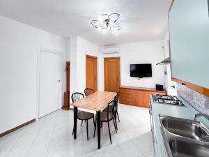eine Küche und ein Esszimmer mit einem Holztisch in der Unterkunft La Dimora di Helen in Monopoli