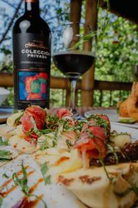 een bord eten op een tafel met een fles wijn bij Villa Maria Tayrona, Jungle and Sea Experience in Los Naranjos