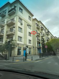 a man standing in front of a building with a red arrow at NIZAMI Street flat in Baku