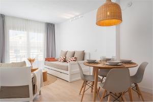 sala de estar con mesa y sofá en Bauló Mar Apartments, en Can Picafort