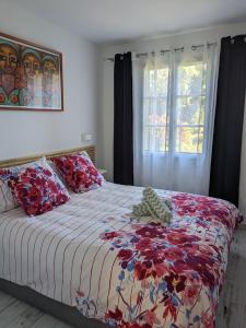 ein Schlafzimmer mit einem Bett mit einer bunten Decke und einem Fenster in der Unterkunft Joli F2 Saint Endreol HAMEAU PALAYSON Var in La Motte