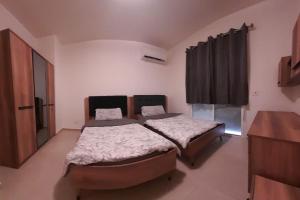 Holiday apartment in zahle with a Panoramic View في زحلة: غرفة نوم بها سريرين وخزانة ملابس