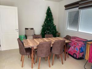 Holiday apartment in zahle with a Panoramic View في زحلة: غرفة طعام مع شجرة عيد الميلاد وطاولة خشبية +13 صورة