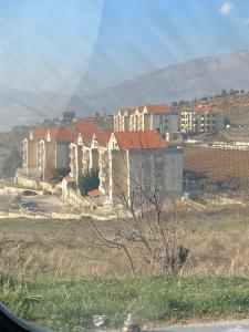 Holiday apartment in zahle with a Panoramic View في زحلة: مجموعة من المنازل في حقل بها مبانٍ