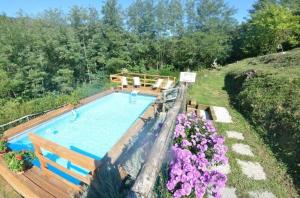 una piscina en un patio con flores púrpuras en Ferienhaus mit Privatpool für 6 Personen ca 95 qm in Castelvecchio, Toskana Provinz Pistoia en Aramo