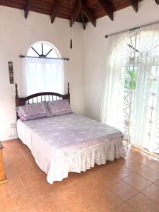 a bedroom with a bed and two large windows at Golden View in St Mary