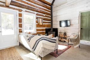 a bedroom with wooden walls and a bed and a tv at Cottontail Cabin with Hot Tub and wood fired Sauna in Merrickville