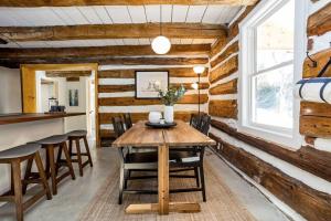 uma sala de jantar com uma mesa de madeira e cadeiras em Cottontail Cabin with Hot Tub and wood fired Sauna em Merrickville