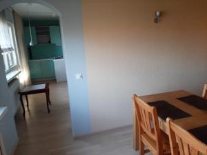 a kitchen and dining room with a table and chairs at Tallinn Airport Apartment in Petrikyula