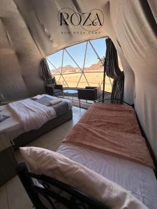 2 letti in tenda con vista su un campo di Rum Roza luxury camp a Wadi Rum