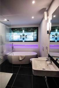 een badkamer met een wit bad en een wastafel bij Aviatorloft in Neuwied
