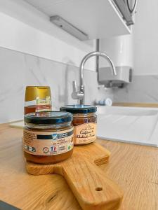 zwei Gläser Erdnussbutter auf einem Holzschnitttafel in der Unterkunft L'évasion paisible à Ouistreham in Ouistreham