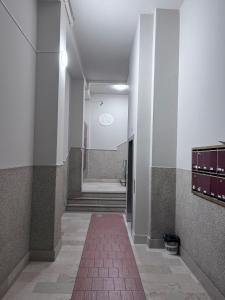 um corredor com piso em azulejo vermelho e uma escada em B&Bononia View em Bolonha
