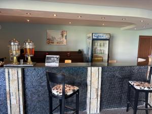 un restaurante con bar con 2 sillas y nevera en Panorama Resort Bansko Wellness & Recreation en Bansko