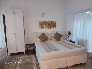 a white bedroom with a large bed and a cabinet at Romantik Pearl with free EV Ch-Station in Valbandon +31 photos