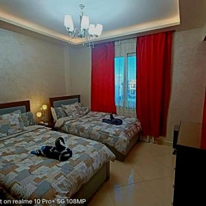 two beds in a room with red curtains at Sharm Hills Hotel in Sharm El Sheikh