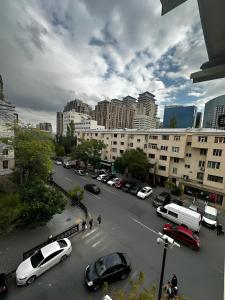 een stadsstraat met auto's geparkeerd op een parkeerplaats bij NIZAMI Street flat in Baku