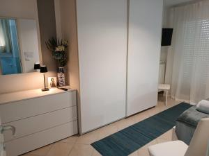 a living room with a dresser and a mirror at ARMAREAOVERSEASSUITES 1 in Fiumicino