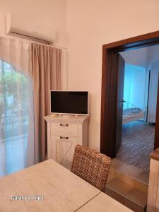 a living room with a television and a table with a chair at Romantik Pearl with free EV Ch-Station in Valbandon