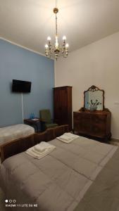 1 dormitorio con 2 camas y lámpara de araña en La Dimora Di Anna, en Chiusi