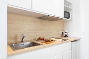 a kitchen with a sink and a bowl of fruit at Bauló Mar Apartments in Can Picafort