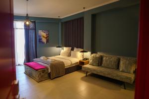 a bedroom with a bed and a couch at Boulevardside in Batumi