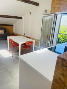 a kitchen with a white table and red chairs at Affittacamere Nonna Ida in Carpi +7 photos