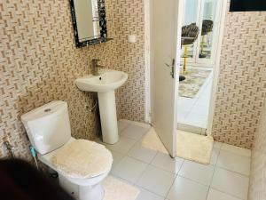 a bathroom with a toilet and a sink at Keur GORA, Sacré cœur 2 in Dakar