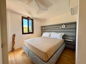 a bedroom with a large bed in a room with a window at One & Only in Cala Bitta