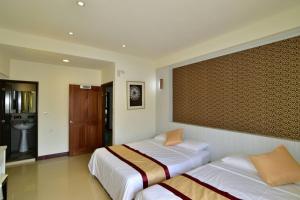 a bedroom with two beds and a bathroom at Penghu Luna Sea Homestay in Magong