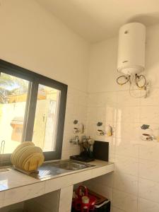a kitchen with a sink and a window at Keur GORA, Sacré cœur 2 in Dakar