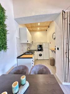 Una cocina con gabinetes blancos y una mesa con sillas. en Cantinho da Verdade, en Odiáxere 5 fotos más