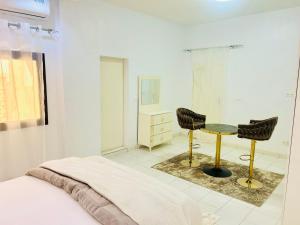 a bedroom with a bed and a table and chairs at Keur GORA, Sacré cœur 2 in Dakar