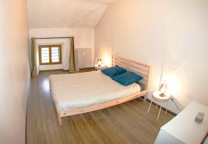 Un dormitorio con una cama con almohadas azules. en SUITE dans VILLA MEXICAINE en Jausiers