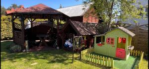 een speelgoedhuis met een speeltuin in de tuin bij Andromeda in Mikoszewo