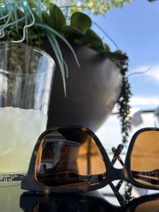 un par de gafas de sol sentadas en una mesa junto a un vaso de agua en Belle Vue Cottage - Kelowna, BC en Kelowna