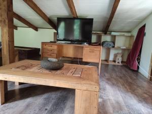 sala de estar con TV sobre una mesa de madera en Relun Lodge en Villarrica