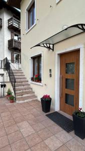 a house with a wooden door and stairs at Garda View Apartment in Tenno