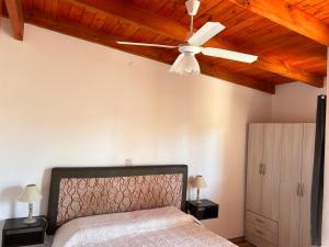 1 dormitorio con ventilador de techo y 1 cama en El 8 del mirador en Villa Santa Cruz del Lago