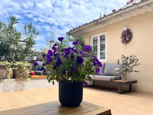 een vaas gevuld met paarse bloemen op een patio bij Irin Hotel in Antibes
