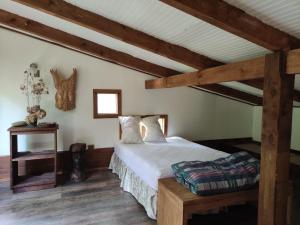 1 dormitorio con cama y techo de madera en Relun Lodge en Villarrica