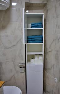 uma casa de banho com um WC branco e toalhas azuis em Andreja em Imotski
