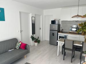 een woonkamer met een bank en een tafel en een keuken bij Marton Apartman in Balatonszemes