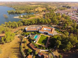 eine Luftansicht eines Hauses neben einem See in der Unterkunft Alentejo Star Hotel - Sao Domingos - Mertola - Duna Parque Group in Mina de São Domingos