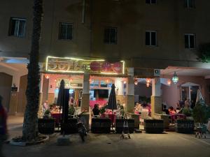 un restaurante con gente sentada fuera por la noche en Riad Palmeraie en Marrakech
