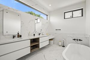 uma casa de banho branca com uma banheira e um lavatório em New Lavish Elegant 3BR Home in Mar Vista, Pet Friendly! 10min to Venice Beach! em Los Angeles