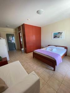 een grote slaapkamer met een bed en een bank bij Nefeli Apartments in Stoupa