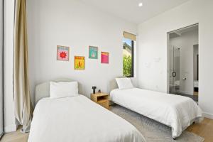 Duas camas num quarto com paredes brancas em New Lavish Elegant 3BR Home in Mar Vista, Pet Friendly! 10min to Venice Beach! em Los Angeles