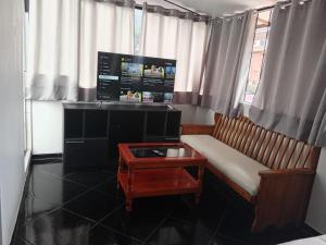 una camera con divano, tavolo e finestra di HOSTAL La RASA a Cuzco